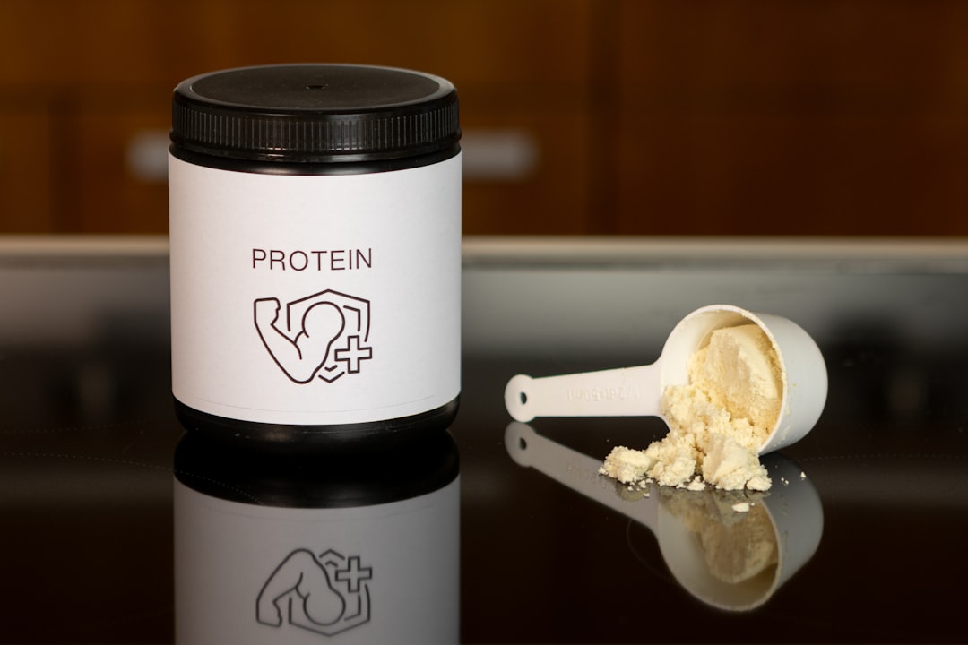 a jar of protein powder next to a spoon